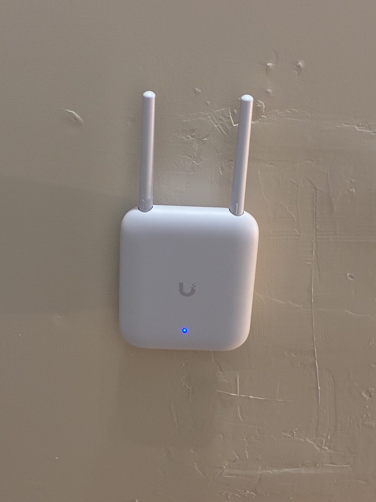 UniFi wireless access point mounted on a wall